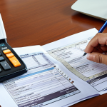 **Image Prompt:** A Malaysian tax accountant meticulously reviewing financial documents with a calculator and pen, highlighting tax deductions and credits for a local business owner. The setting is a modern office with Malaysian currency visible, emphasizing compliance and strategic tax planning in a Malaysian context.